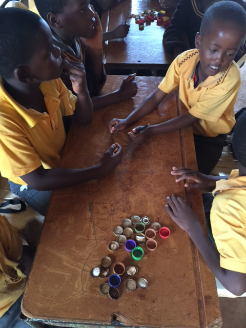 School children at Emvembili Central Primary School learning math lessons aided by bottle caps