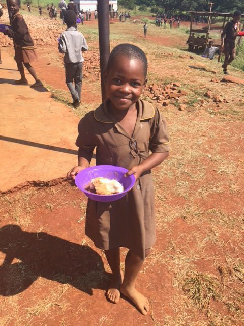 Young girl in Swaziland enjoying breakfast before her school day.
